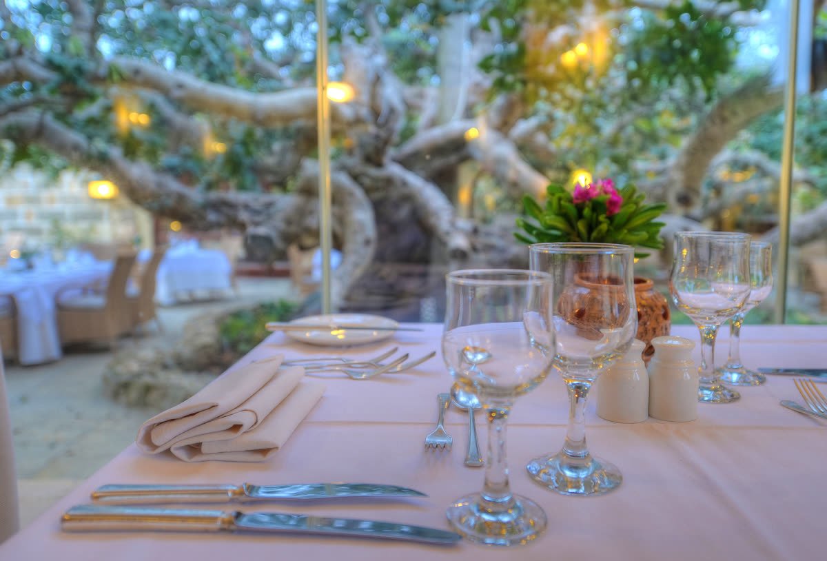 Table set beneath the carob tree at Il Carrubo